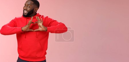Photo for Someone love ya. Portrait enthusiastic creative cute black boyfriend wearing red hoodie show heart sign smiling broadly confessing love sympathy look passionate, express romance pink background. - Royalty Free Image