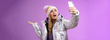 Photo for Upset bothered whining blond girl complaining cannot find right angle take selfie with cool sightseeing during vacation travelling abroad yelling smartphone pointing aside, purple background. - Royalty Free Image