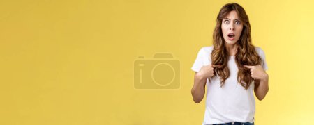Photo for Shocked concerned questioned curly-haired girl drop jaw gasping stare offended surprised pointing herself feel accused reacting blame shook misunderstanding stand yellow background insulted. - Royalty Free Image