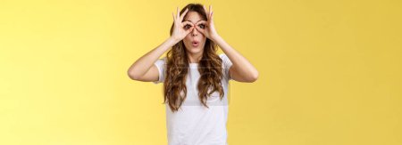 Photo for Wow so cool. Girl obersve interesting awesome event show okay perfection gesture look through ring hands folding lips amused wondered glance camera fascinated admiration interested yellow background. - Royalty Free Image