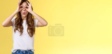 Photo for Wow so cool. Girl obersve interesting awesome event show okay perfection gesture look through ring hands folding lips amused wondered glance camera fascinated admiration interested yellow background. - Royalty Free Image