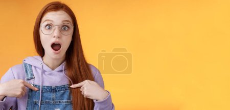 Téléchargez les photos : Mode de vie. Choqué émotif surpris rousse européenne femme portant des lunettes sweat à capuche goutte mâchoire étourdi se montrant complètement incrédule ne peut pas croire gagner étant choisi look impressionné orange - en image libre de droit
