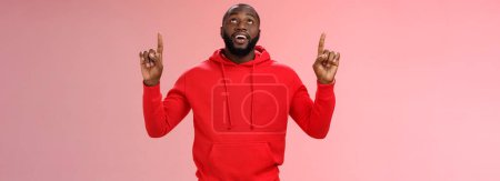 Photo for Fascinated attractive black bearded boyfriend gazing shooting star raise head impressed smiling amused pointing up curiously looking upwards, standing pink background enjoy stargazing. - Royalty Free Image