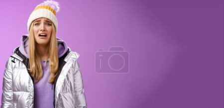 Photo for Upset sobbing miserable cute blond woman in silver stylish jacket hat crying whining unhappy feel sadness distress look disappointed complaining cruel life, unlucky standing purple background. - Royalty Free Image