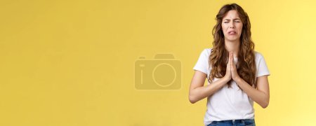Photo for Please beg you. Sobbing timid insecure distressed cute whining girl crying upset close eyes grimacing hold hands pray pleading asking favour apologizing sincere hope for pity yellow background. - Royalty Free Image