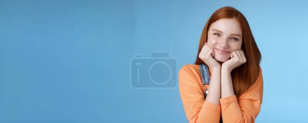 Photo for Tenderness, wellbeing, beauty conept. Attractive young ginger girl pure skin blue eyes lean palms silly smiling camera look amused enthusiastic listen interesting stories gladly, blue background. - Royalty Free Image