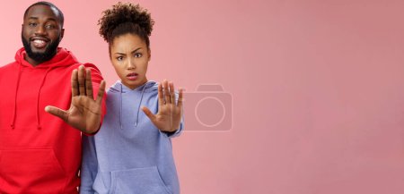 Photo for Friend asking stop worrying health raise palm forbidden enough dangerous gesture. Two african american man woman show hand prohibition taboo gesture persuading quit smoking, pink background. - Royalty Free Image