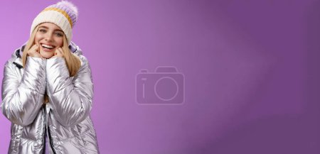 Foto de Estilo de vida. Encantada encantadora hembra tierna con estilo lindo sombrero de plata brillante chaqueta magra barbilla manos sonriendo suspirando disfrutando viendo encantadora escena romántica quiere enamorarse de pie felizmente púrpura - Imagen libre de derechos