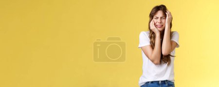 Photo for Offended silly timid insecure girl crying feel scared insulted close eyes whining grab head being victim sorry herself after huge quarrel sobbing stand yellow background upset distressed. Lifestyle. - Royalty Free Image