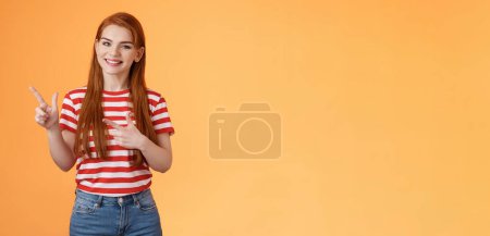 Photo for Cheerful pleasant female professional assistant showing customers office, pointing left smiling cheerful, gladly help out pick product, introduce new promos copy space, stand orange background. - Royalty Free Image