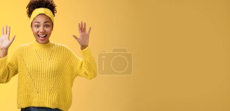 Téléchargez les photos : Charme excité souriant amical millénial afro-américaine fille lever les mains rien cacher montrer paumes haute reddition debout amusé excité sourire s'amuser posant fond jaune. - en image libre de droit