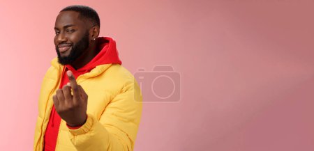 Cheeky flirty black bearded guy asking come closer beckon index finger camera smiling make smug face have plans for you alluring join, standing pink background devious grin. Emotions concept