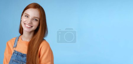 Photo for Pleasant sincere happy ginger girl blue eyes tilting head grinning happily laughing stay positive lucky spend time best friends receive praises compliments good job smiling delighted, blue background. - Royalty Free Image