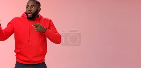 Photo for Shocked stunned man widen eyes gasping drop jaw standing stupor pointing look left astonished witnessing terrible breathtaking scene, standing pink background pale freak-out start panic. - Royalty Free Image