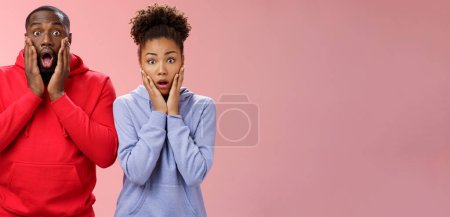 Photo for Amazed shocked gasping speechless two african american man woman drop jaw press palms cheeks worried nervous sympathizing terrible story standing stunned imrpessed pink background, feel sorry. - Royalty Free Image
