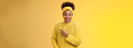 Photo for Friendly ougoing relaxed african-american woman casually pointing right during conversation discussing recent new cafe open awesome discounts promos standing happily yellow background. Copy space - Royalty Free Image