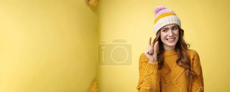 Photo for Displeased attractive picky woman describing small object show tiny thing cringing dislike disappointment look upset fingers, describing little salary new job, standing yellow background awkward. - Royalty Free Image