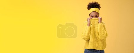 Photo for Cute upset scared timid insecure african-american offended girl hiding face pulling sweater collar nose frowning pouting look sorrow insulted afraid watching scary horror movie alone, need support. - Royalty Free Image