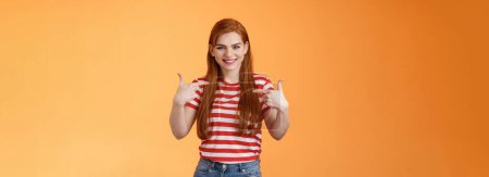 Photo for Skilful good-looking redhead motivated girl, pointing herself, indicate fingers chest, bragging joyfully smiling, boastful chat own achievement, stand orange background assertive, wanna participate. - Royalty Free Image