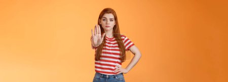 Photo for Serious-looking confident brave redhead girl oppose haters, fighting for freedom, prohibit illegal actions, extend hand stop enough, never or forbidden gesture, look determined camera. - Royalty Free Image