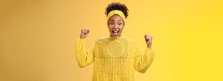 Téléchargez les photos : Oui, enfin le mien. excité surpris amusé afro-américain fille célébrant victoire achivement acclamations souriant largement crier repos poings triompher succès, debout fond jaune. - en image libre de droit