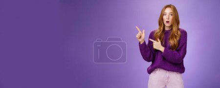 Photo for Lifestyle. Stunned girl asking friend if she saw it drop jaw from stupor and amazement popping eyes at camera after witnessing shocking revelation pointing questioned at upper left corner over purple - Royalty Free Image