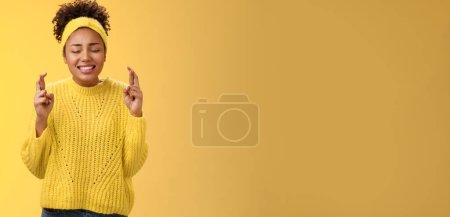 Foto de Nervioso fiel intenso afroamericano chica cerrar los ojos cruzan los dedos buena suerte orando haciendo deseo pidiendo a Dios ayuda sueño hecho realidad, con suerte anticipando milagro buenos resultados positivos. - Imagen libre de derechos
