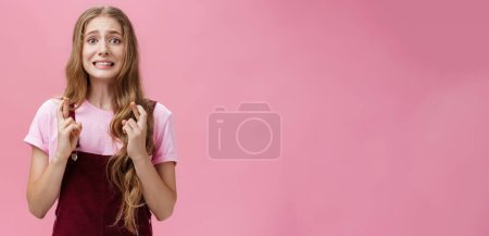 Photo for Woman overreacting feeling worried for important result waiting nervously crossing fingers for good luck clenching teeth and frowning looking concerned at camera, praying hopefully for wish come true. - Royalty Free Image