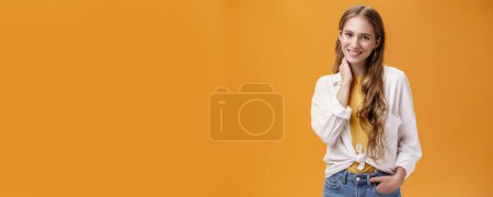 Photo for Girl dressing up for success. Charming feminine and stylish young female with wavy natural hairstyle touching neck timid and shy smiling cheerfully at camera wearing large earrings and blouse. - Royalty Free Image