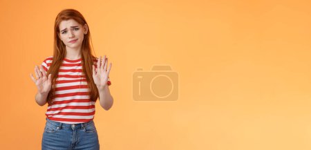 Photo for No thanks Im good. Unimpressed redhead female refuse taking party event show stop rejection sign raise palms not gesture, smirk displeased careless, stand uninterested orange background. - Royalty Free Image