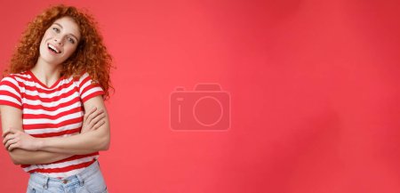 Photo for Lifestyle. Cheerful carefree redhead playful relaxed curly girl tilt head smiling happy cross arms chest wanna fill summer vacation perfect holiday memories standing red background striped t-shirt. - Royalty Free Image