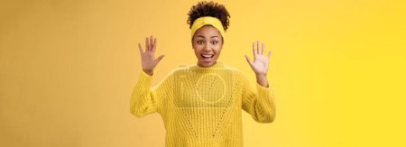 Téléchargez les photos : Charme excité souriant amical millénial afro-américaine fille lever les mains rien cacher montrer paumes haute reddition debout amusé excité sourire s'amuser posant fond jaune. - en image libre de droit