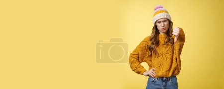 Photo for Lame dislike unfollow. Portrait disappointed displeased picky young judgemental woman show thumb-down cringing grimacing unsatisfied expressing disapproval antipathy, yellow background. - Royalty Free Image