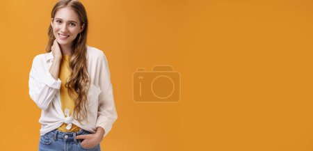 Photo for Girl dressing up for success. Charming feminine and stylish young female with wavy natural hairstyle touching neck timid and shy smiling cheerfully at camera wearing large earrings and blouse. - Royalty Free Image