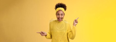 Photo for Energized active charismatic african-american woman afro hairstyle in sweater headband screaming fascinated enthusiastic pointing left right impressed variaty awesome choices, picking products. - Royalty Free Image