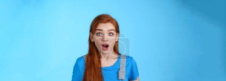 Photo for Shocked redhead girl react omg shook, drop jaw speechless, stare impressed gasping amazed, hear surprising news, stand blue background stunned, find out truth, found good opportunity. - Royalty Free Image