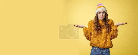 Photo for How should I know. Portrait confused perplexed worried cute female assistant shrugging spread hands sideways clueless unaware cannot understand what happened unsure, unaware yellow background. - Royalty Free Image