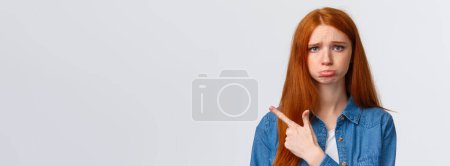 Photo for Close-up portrait insecure, upset and gloomy cute redhead girl sobbing, feeling unfair and jealous, complaining, asking favour, want buy something ask permission, pointing left. - Royalty Free Image