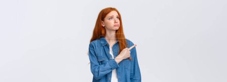 Photo for So pity. Upset gloomy cute redhead female student lost her chance participate exchange program, sobbing and looking grumpy pointing upper left corner, express regret and disappointment. - Royalty Free Image