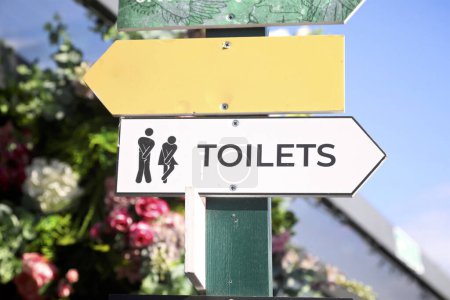 Photo for Wooden sign pointing to the laides and gentlemens toilets - Royalty Free Image