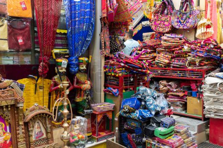 Photo for Jodhpur, Rajasthan, India - 19.10.2019 : Colorful Rajasthani ladies bags and clothes are displayed for sale at famous Sardar Market and Ghanta ghar Clock tower in Jodhpur, Rajasthan, India. - Royalty Free Image