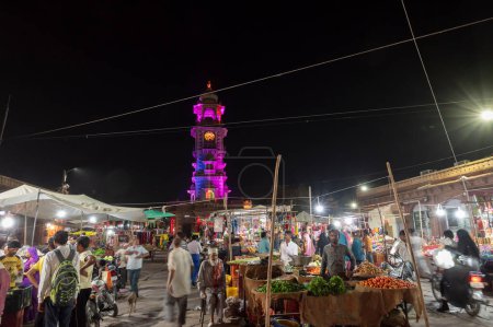 Photo for Jodhpur, Rajasthan, India - 18.10.2019 : Famous Sardar Market and Ghanta ghar Clock tower at night in Jodhpur, Rajasthan, India. Street vendors and market place in foreground. - Royalty Free Image