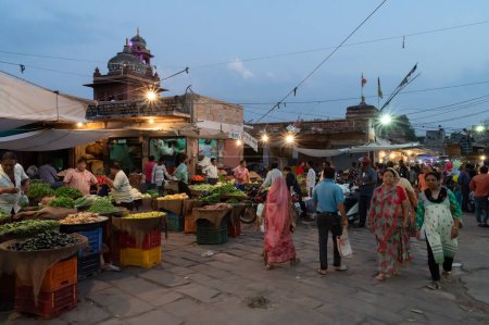 Photo for Jodhpur, Rajasthan, India - 20.10.2019 : Rajasthani buyers and sellers at famous Sardar Market and Ghanta ghar Clock tower in Jodhpur, Rajasthan, India. Blue hour image. - Royalty Free Image