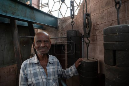 Photo for Jodhpur, Rajasthan, India - 16.10.2019 : Old man with engineering knowledge, instruments and machineries running the decades old clock of Ghanta ghar or Clock tower in Jodhpur, Rajasthan, India. - Royalty Free Image