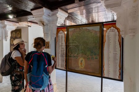 Téléchargez les photos : Jaisalmer, Rajasthan, Inde - 15 octobre 2019 : Des touristes étrangers étudiant la généalogie du Seigneur Shri Krishna exposés à l'intérieur de Rani Mahal ou Rani Ka Mahal, à l'intérieur du fort de Jaisalmer. - en image libre de droit