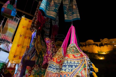 Photo for Jaisalmer,Rajasthan,India - October14,2019 : Womens' saree and bag are being sold at market place beside Jaisalmer Fort or Golden Fort. A living fort -made of yellow sandstone. UNESCO heritage site. - Royalty Free Image