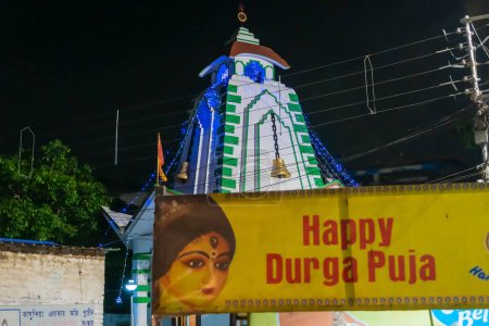 Photo for Howrah, West Bengal, India - April 14th, 2019 : Banner of Durga Puja wihses in front of temple of Lord Shiva on the eve of bengali new year , known as Gajan or Charak festival , at night. - Royalty Free Image