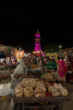 Photo for Jodhpur, Rajasthan, India - 20.10.2019 : Rajasthani street food is being sold at road side food stall at night at famous Sardar Market and Ghanta ghar Clock tower in Jodhpur, Rajasthan, India. - Royalty Free Image