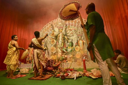 Photo for Howrah, India -October 13, 2021 : Hindu Priests worshipping Goddess Durga with panchapradip, ghanta, chamor and hand fan. Ashtami puja aarati - sacred Durga Puja ritual - shot at night. - Royalty Free Image