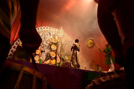 Foto de Howrah, West Bengal, India -October 13, 2021 : Dhaakis playing dhaaks while Hindu Priests worshipping Goddess Durga. Ashtami puja aarati - sacred Durga Puja ritual. - Imagen libre de derechos
